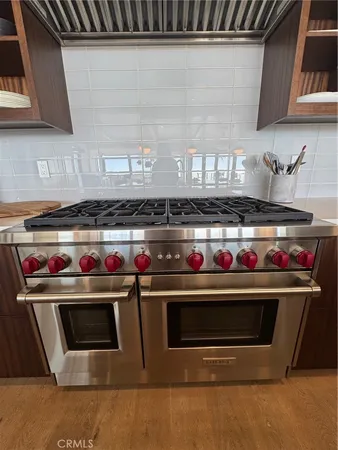 a kitchen with a stove and wooden cabinets