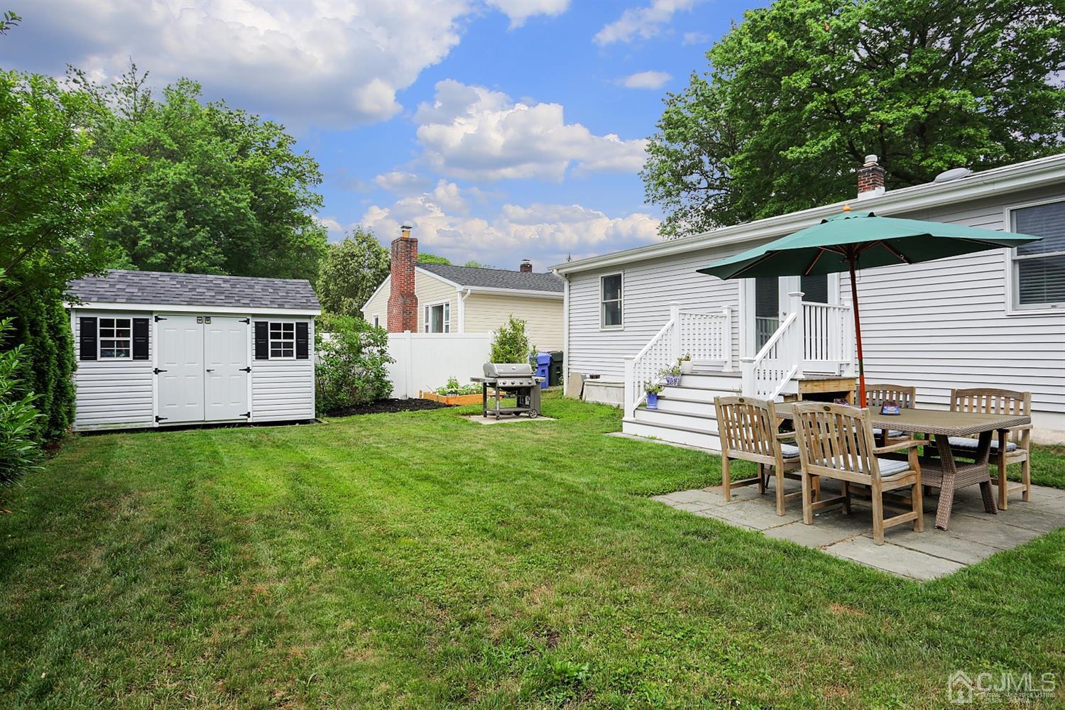 39 West Hill Road Colonia, NJ 07067 - Photo 22 of 26 a backyard of a house with table and chairs