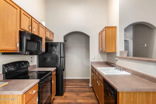 a kitchen with stainless steel appliances granite countertop a sink a stove and a refrigerator