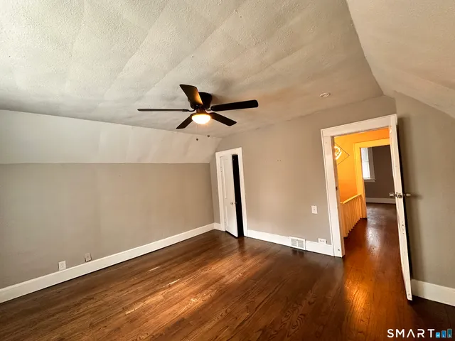 a view of empty room with wooden floor