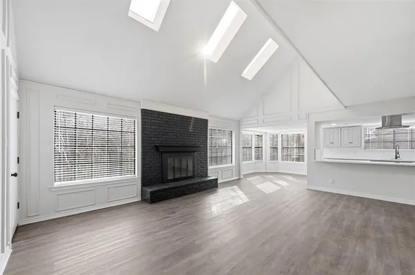 a view of wooden floor fire place and windows in a room