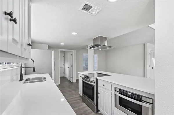 a kitchen with stainless steel appliances a stove a sink and a refrigerator