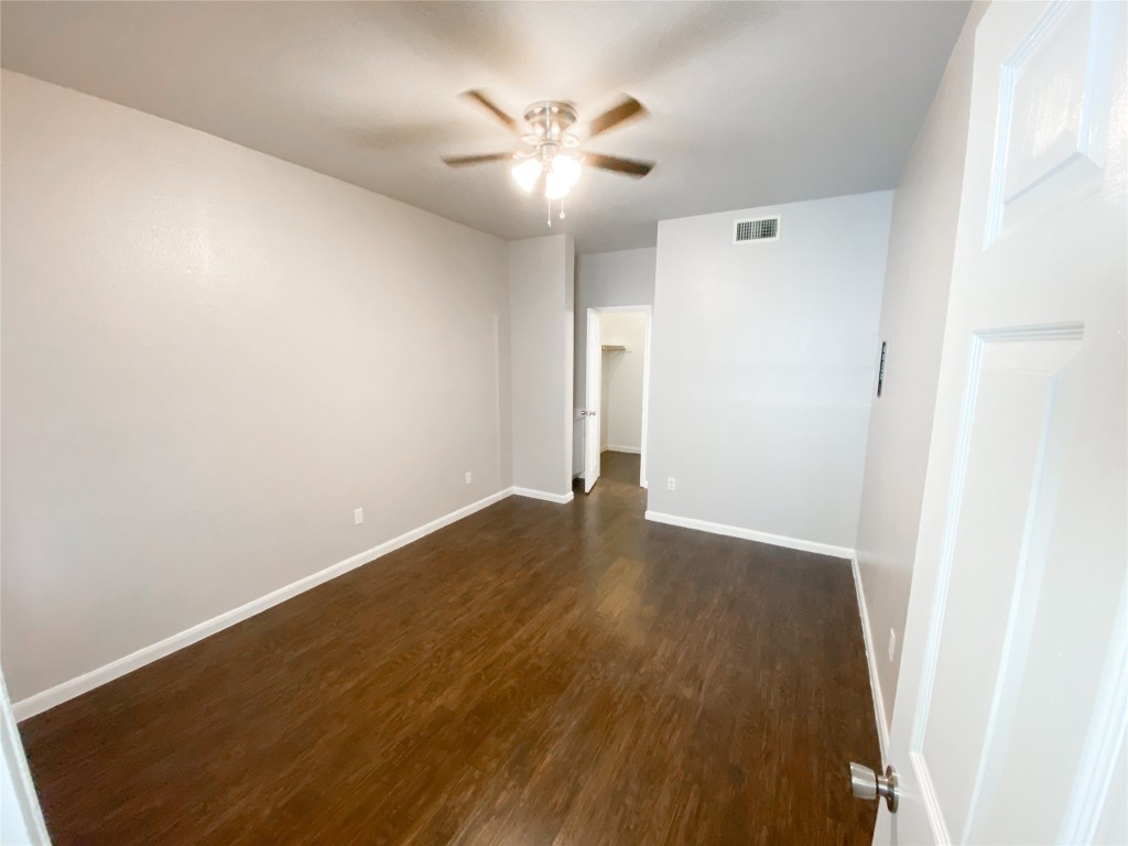 2529 Rio Grande Street, Unit 34 Austin, TX 78705 - Photo 10 of 17 an empty room with wooden floor and a ceiling fan