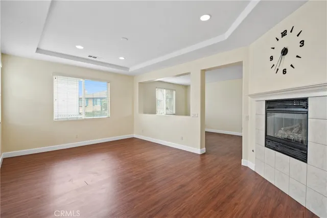 an empty room with windows and fireplace