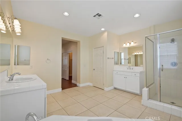 a bathroom with a double vanity sink mirror and shower