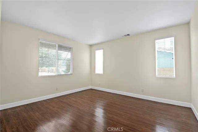 a view of a room with wooden floor and windows in it