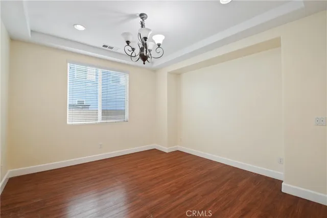 a view of a room with wooden floor and chandelier