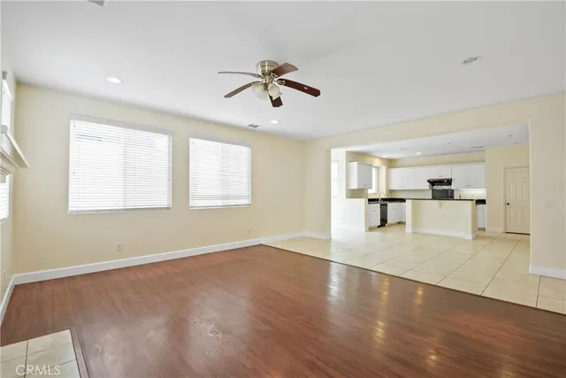 a view of empty room with wooden floor and window