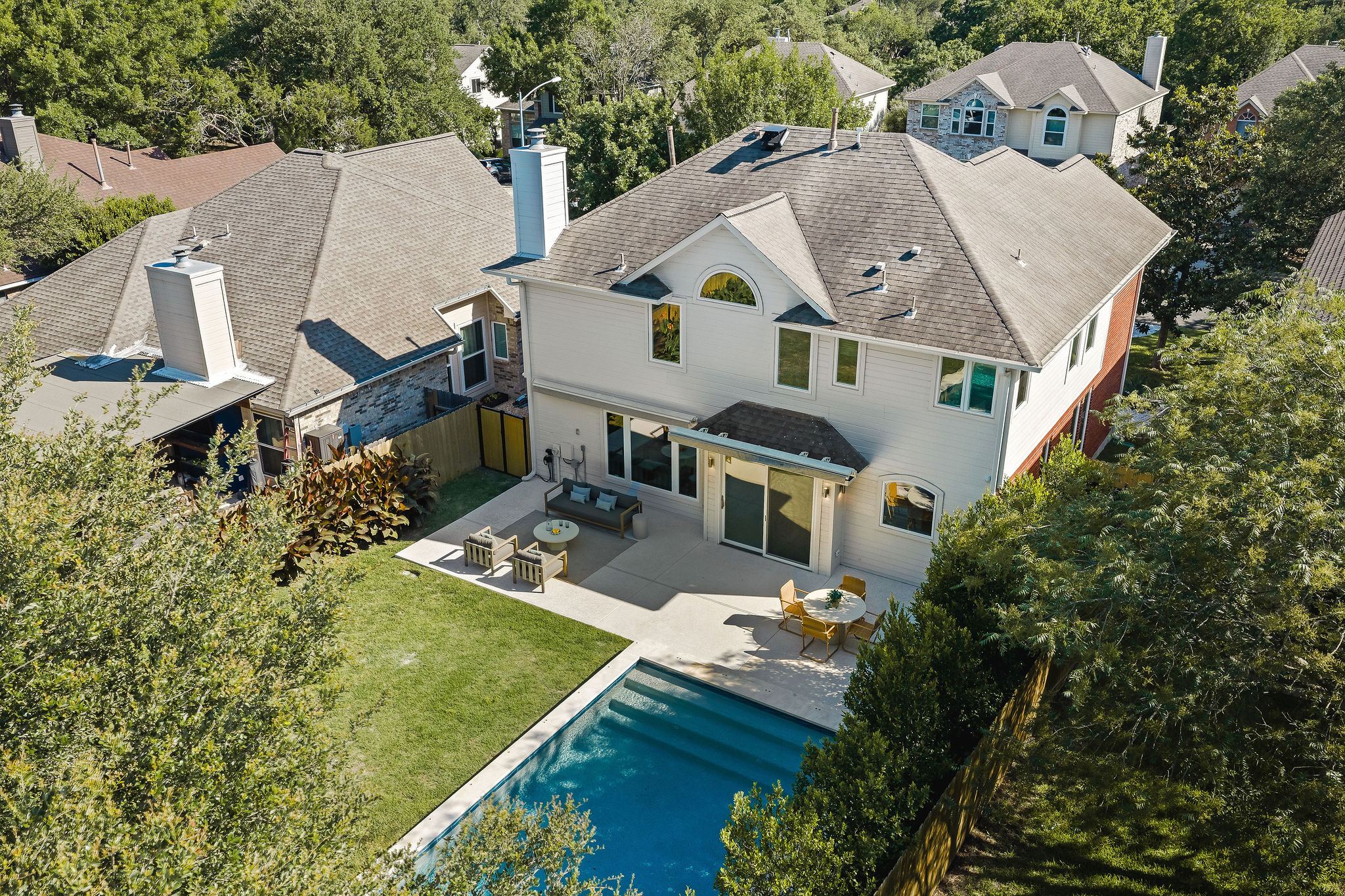 6500 Clay Allison Pass Austin, TX 78749 - Photo 38 of 39 Rear exterior featuring a rectangular in-ground swimming pool, a concrete patio, and a manicured lawn