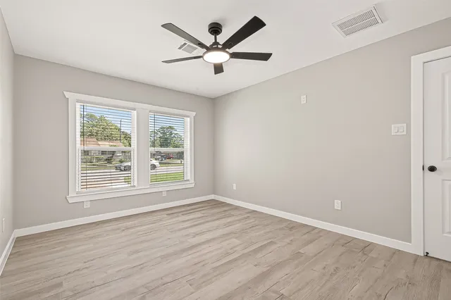 wooden floor in an empty room with a window