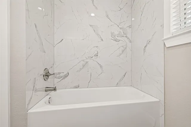 a bathroom with bathtub and shower