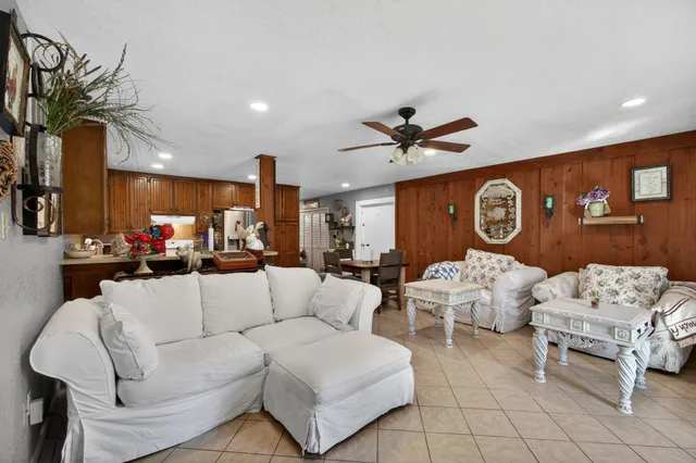 a living room with furniture kitchen view and a chandelier