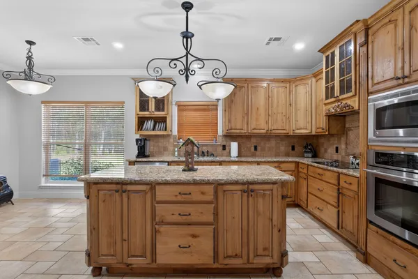 a kitchen with a center island wooden cabinets and window