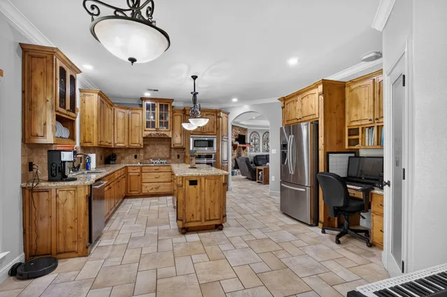 a kitchen with stainless steel appliances granite countertop a sink a stove and a refrigerator