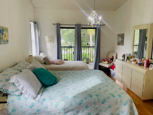a bedroom with a bed mirror and window