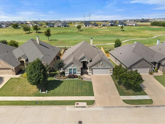 an aerial view of a house with a garden and mountain view