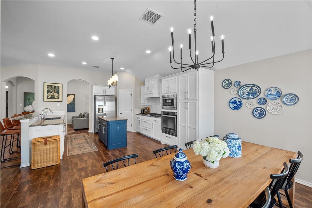 7224 Prestwick Terrace Benbrook, TX 76126 - Photo 23 of 39 a kitchen with stainless steel appliances wooden floor dining table and chairs