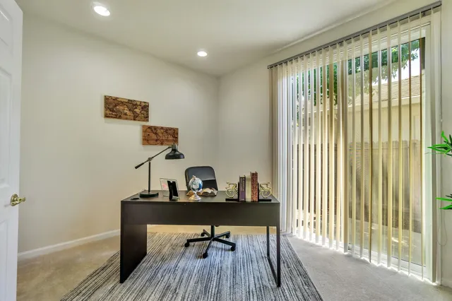a view of a workspace with furniture and a window