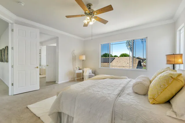 a spacious bedroom with a bed a couch and a chandelier