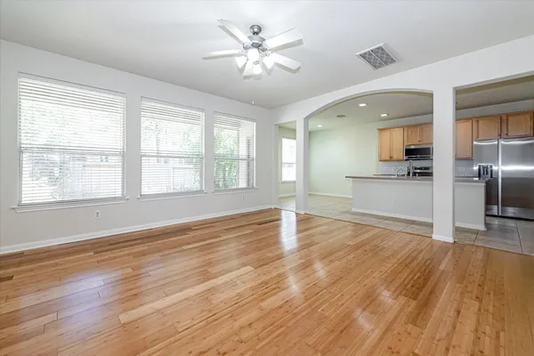 a view of an empty room with window and wooden floor