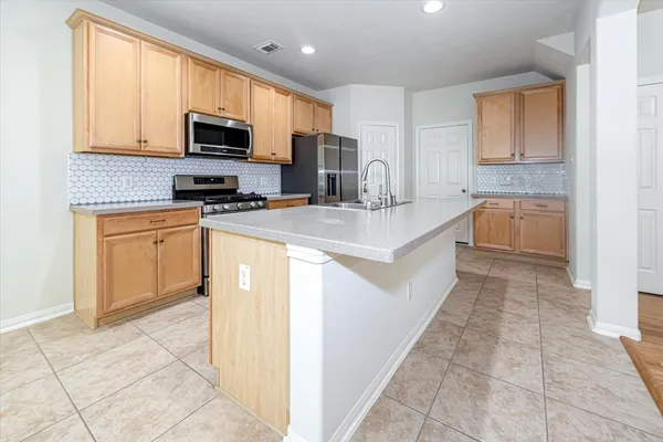 a kitchen with a sink a counter top space appliances and cabinets