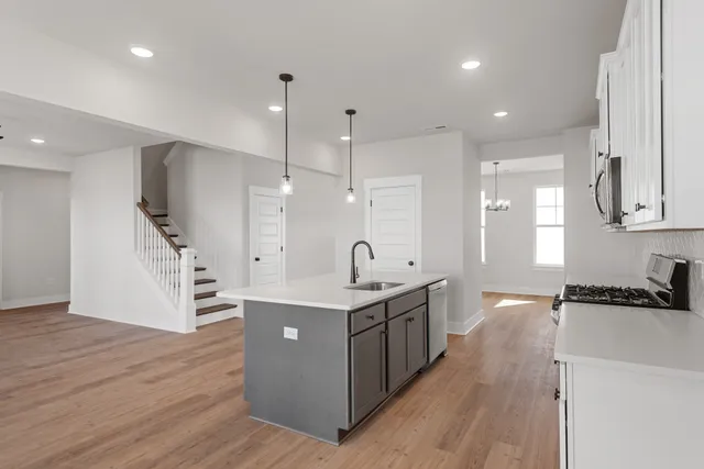 a kitchen with stainless steel appliances granite countertop a sink and a stove top oven
