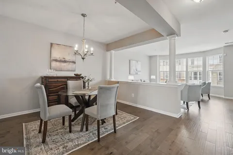 a dining room with furniture a chandelier and wooden floor