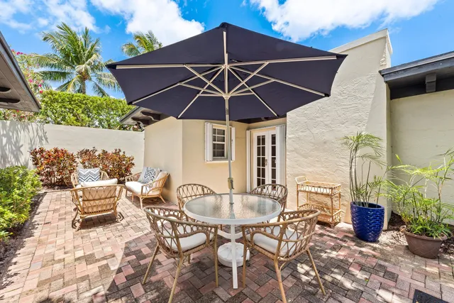 a patio with a table and chairs under an umbrella