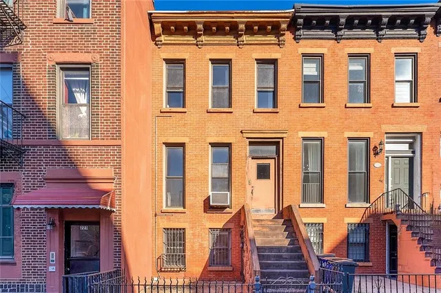 front view of a brick building next to a yard
