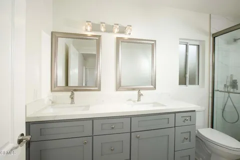 a bathroom with a toilet a sink a mirror and