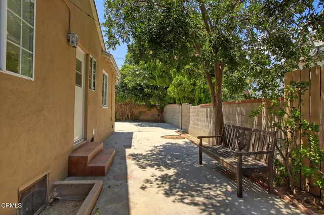 a view of a patio with table and chairs and wooden fence