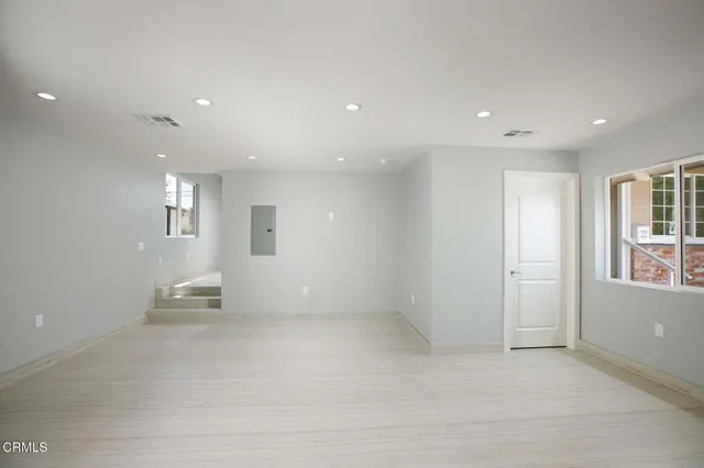an empty room with windows and closet