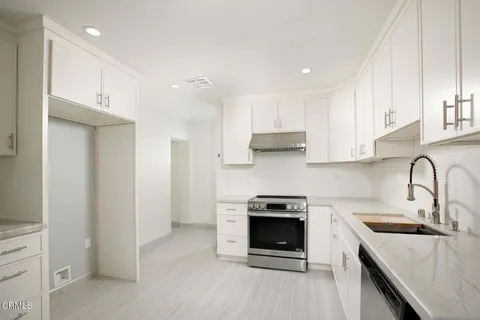 a kitchen with stainless steel appliances granite countertop a stove a sink and a refrigerator