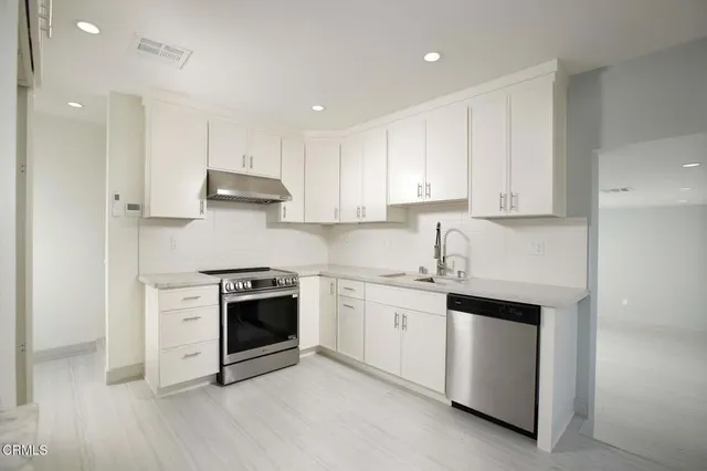 a kitchen with cabinets stainless steel appliances and a sink