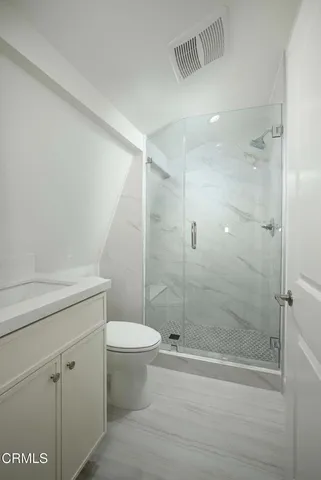 a bathroom with a shower a toilet and sink