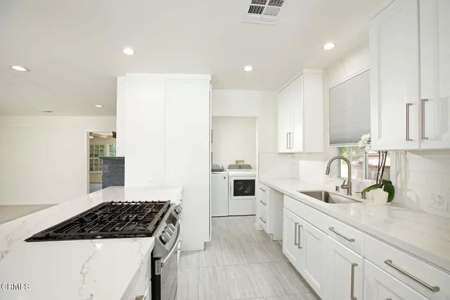 a kitchen with white cabinets and appliances