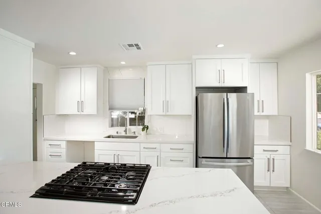 a kitchen with kitchen island white cabinets and stainless steel appliances