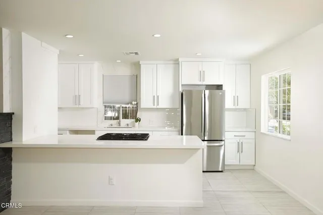 a kitchen with stainless steel appliances granite countertop a refrigerator and a stove