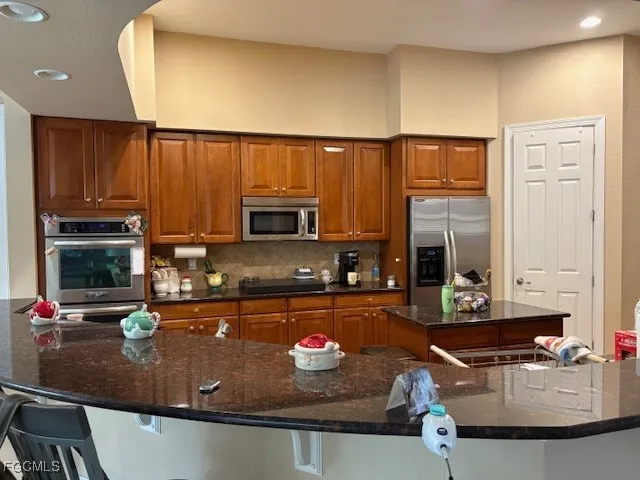 a kitchen with stainless steel appliances granite countertop a sink refrigerator and microwave