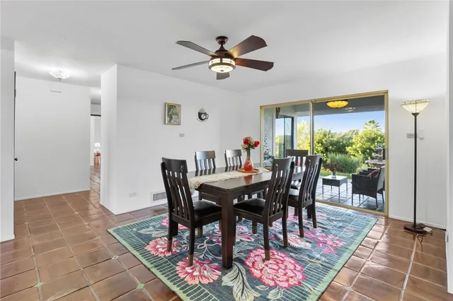 a living room with furniture a flat screen tv and floor to ceiling window