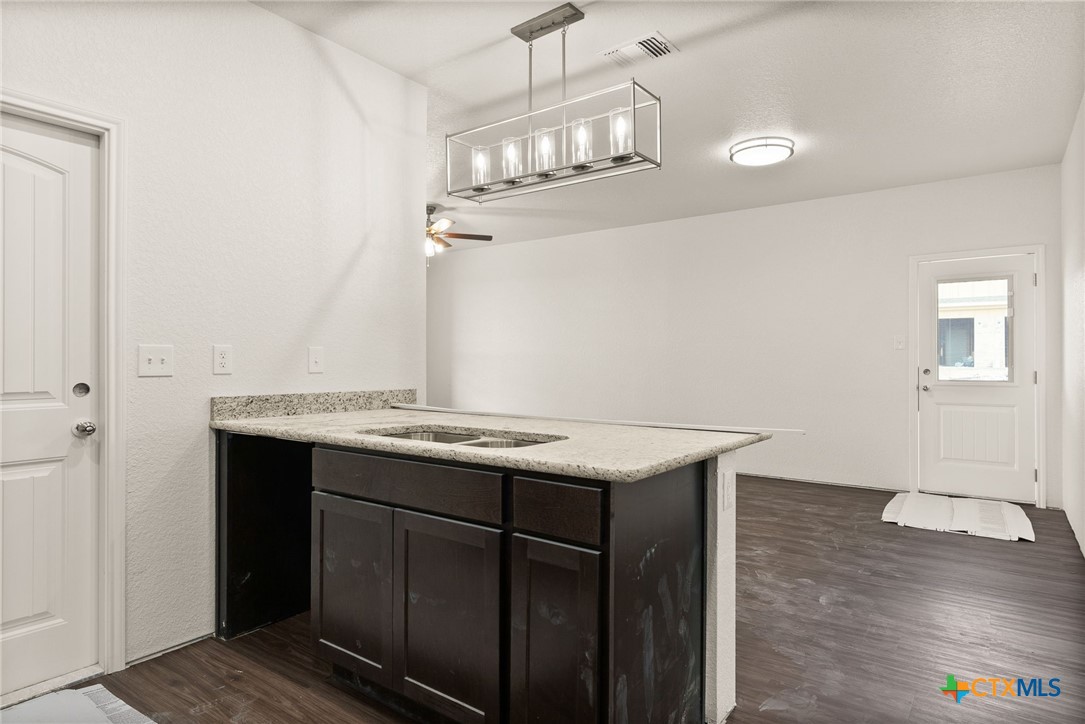 117 Leon Lane Kempner, TX 76539 - Photo 4 of 20 an empty room with kitchen view and wooden floor