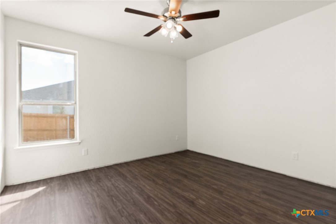 117 Leon Lane Kempner, TX 76539 - Photo 7 of 20 an empty room with wooden floor fan and windows