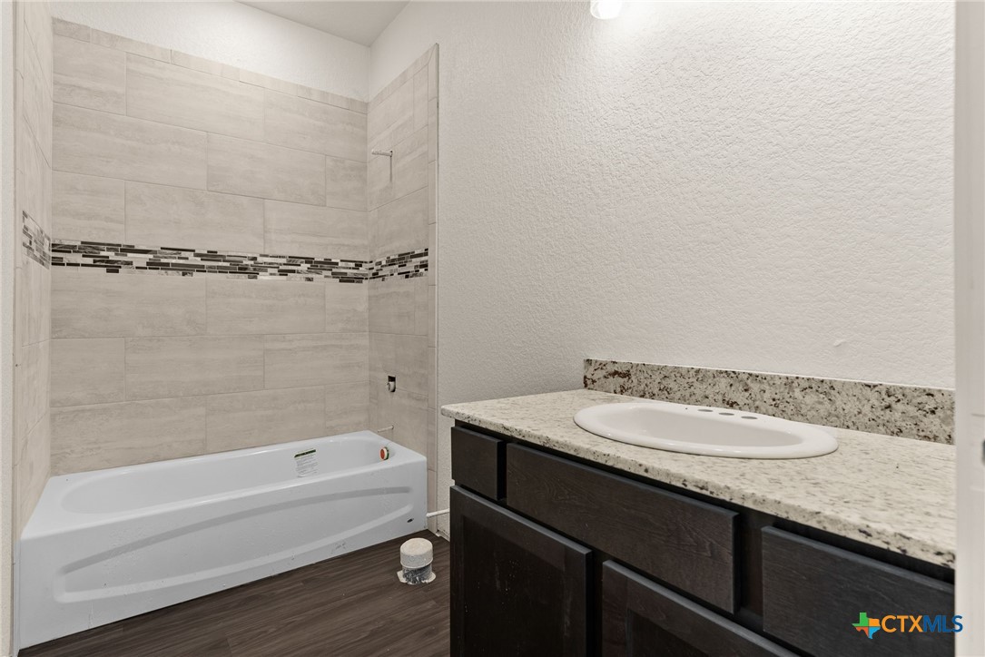 117 Leon Lane Kempner, TX 76539 - Photo 8 of 20 a bathroom with a granite countertop sink and a bathtub