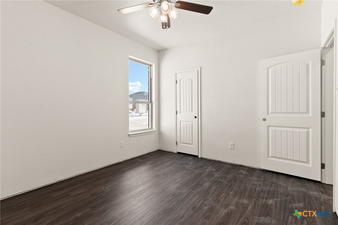 117 Leon Lane Kempner, TX 76539 - Photo 10 of 20 an empty room with wooden floor chandelier fan and windows
