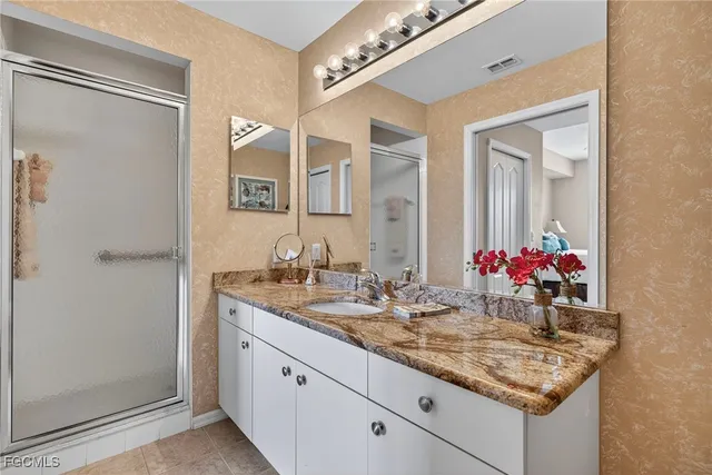 a bathroom with a granite countertop sink and a mirror