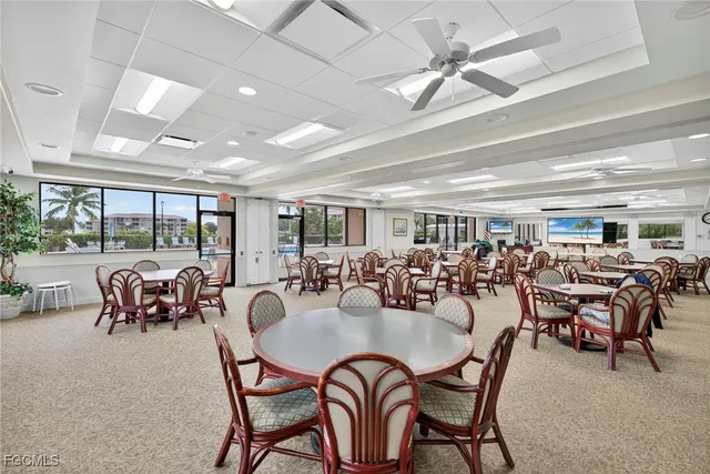 a dining room with furniture water view and a floor to ceiling window