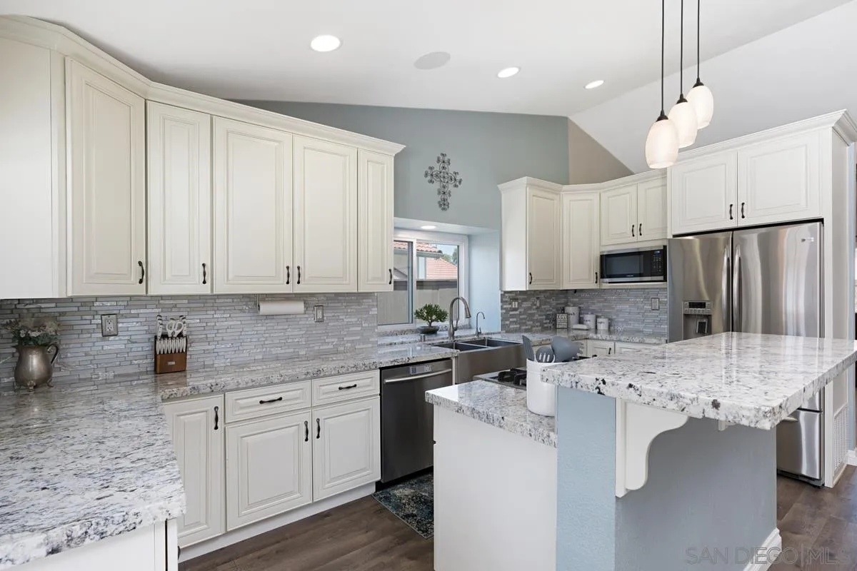 22895 Temet Street Wildomar, CA 92595 - Photo 14 of 36 a kitchen that has a lot of white cabinets and stainless steel appliances