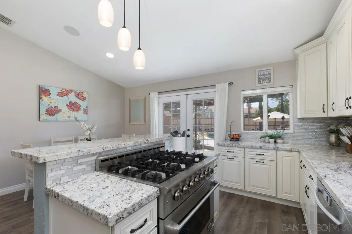 22895 Temet Street Wildomar, CA 92595 - Photo 17 of 36 a kitchen that has a sink a stove and wooden floor