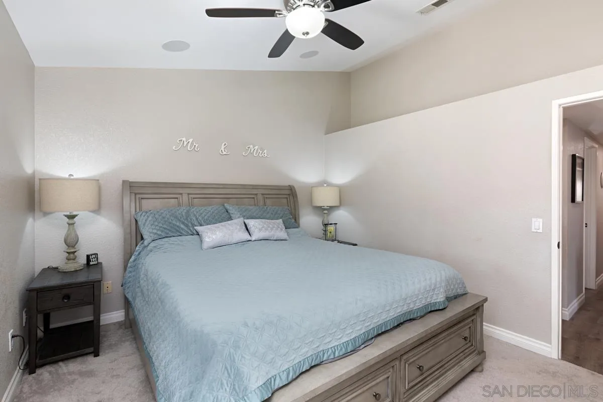 22895 Temet Street Wildomar, CA 92595 - Photo 19 of 36 a bedroom with a bed and a ceiling fan