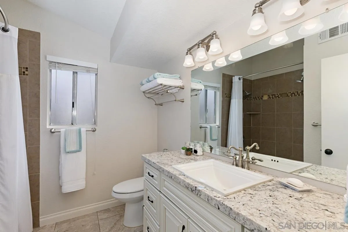 22895 Temet Street Wildomar, CA 92595 - Photo 21 of 36 a bathroom with a granite countertop sink a toilet and a mirror